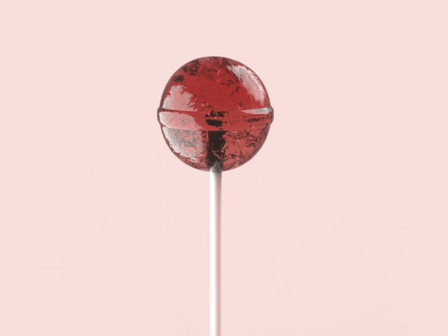 A red lollipop on a pink background.